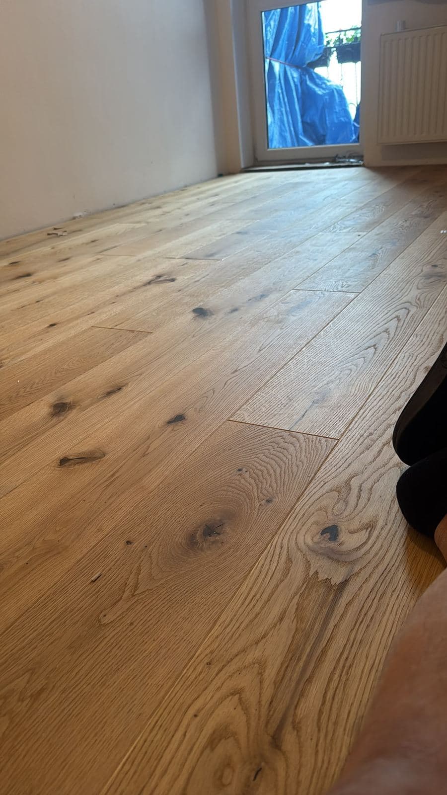 Detail nové dubové podlahy s výraznou kresbou dřeva a suky